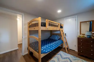 a bedroom with two bunk beds and a mirror at Waterfront Cottage at Highland Lake with Dock in Winsted