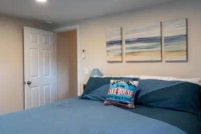 a bedroom with a blue bed with a pillow on it at Waterfront Cottage at Highland Lake with Dock in Winsted