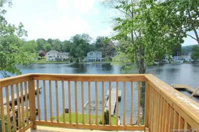 a deck with a view of a river at Waterfront Cottage at Highland Lake with Dock in Winsted
