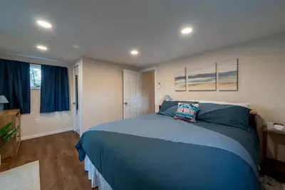 a bedroom with a large blue bed with blue pillows at Waterfront Cottage at Highland Lake with Dock in Winsted