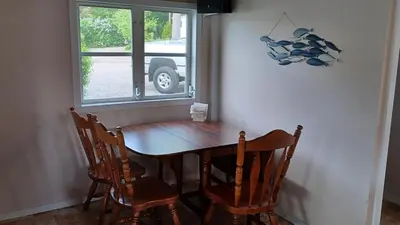 a dining room table with two chairs and a window at Waterfront Cottage at Highland Lake with Dock in Winsted