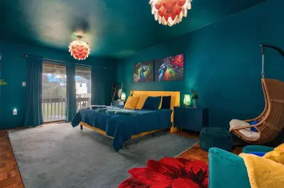 a blue bedroom with a bed and a chair at 10K sqft Estate 2 Pools Pond Games Sauna Hot Tub in East Stroudsburg