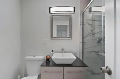 a white bathroom with a sink and a shower at Comfortable Bloomfield 3BR Retreat home in Bloomfield