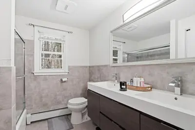 a bathroom with a sink and a toilet and a mirror at Comfortable Bloomfield 3BR Retreat home in Bloomfield