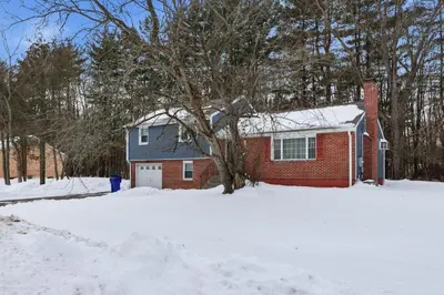 a red brick house in the snow at Comfortable Bloomfield 3BR Retreat home in Bloomfield