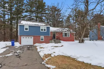 a blue house with a garage in the snow at Comfortable Bloomfield 3BR Retreat home in Bloomfield