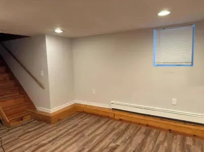 an empty room with a couch and a window at Americana in Jersey City
