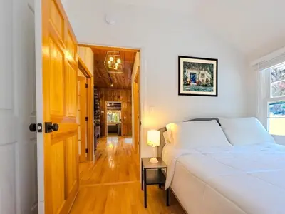 a bedroom with a bed and a table with a lamp at Private, Family-Friendly Home Near Candlewood Lake in New Fairfield