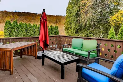 a patio with a table and chairs and an umbrella at Private, Family-Friendly Home Near Candlewood Lake in New Fairfield