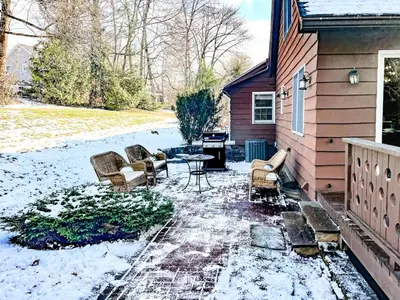 a patio with chairs and a table in the snow at Private, Family-Friendly Home Near Candlewood Lake in New Fairfield
