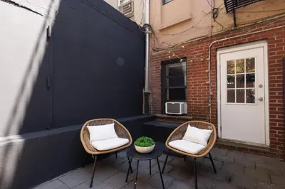two chairs and a table with a plant on a patio at Urban Oasis 1BR East Village Hideaway with Patio! in New York