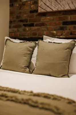 a bed with two pillows and a brick wall at Refined & Stylish Manhattan Haven in New York