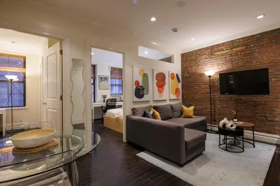 a living room with a couch and a tv at Refined & Stylish Manhattan Haven in New York