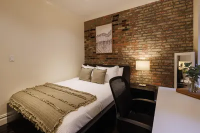 a bedroom with a bed and a brick wall at Refined & Stylish Manhattan Haven in New York
