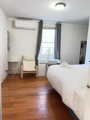 a bedroom with two beds and a desk and a chair at New York Flushing private room in Flushing