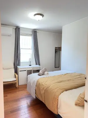a bedroom with two beds and a desk and a window at New York Flushing private room in Flushing