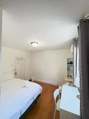 a bedroom with a white bed and a desk at New York Flushing private room in Flushing