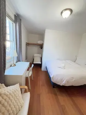 a room with two beds and a table and a desk at New York Flushing private room in Flushing