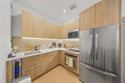 a kitchen with a stainless steel refrigerator and wooden cabinets at The NYC Edition Times Square in New York