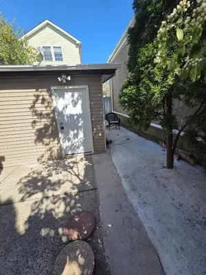 a door to a house with a dog laying on the driveway at Newly Built detached studio apartment with private toilet and bath in Irvington