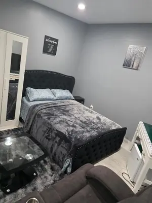 a bedroom with a bed and a couch at Newly Built detached studio apartment with private toilet and bath in Irvington