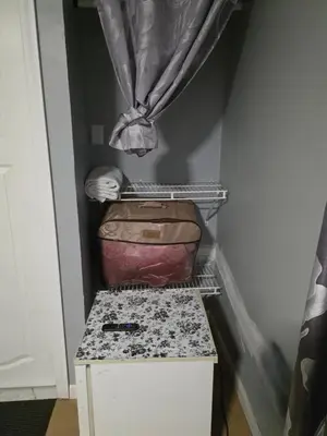 a suitcase sitting on top of a box in a room at Renovated Room with Private Bath in Ground Floor 3BR in Irvington