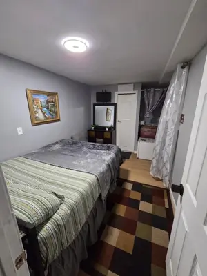a bedroom with a bed and a television in it at Renovated Room with Private Bath in Ground Floor 3BR in Irvington