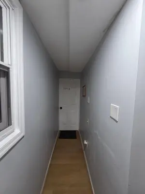 a hallway with a white door and a window at Renovated Room with Private Bath in Ground Floor 3BR in Irvington