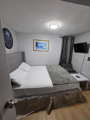 a bedroom with a bed and a desk and a tv at A newly renovated room with private toilet & bathroom in a 3 bedroom apartment on the ground floor in Irvington