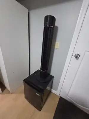 a black stove in a room next to a door at A newly renovated room with private toilet & bathroom in a 3 bedroom apartment on the ground floor in Irvington