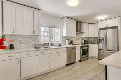 a kitchen with white cabinets and stainless steel appliances at Game Room and Hot Tub Family Gem on Lake Hopatcong