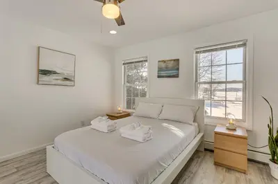 a white bedroom with a bed and two windows at Game Room and Hot Tub Family Gem on Lake Hopatcong