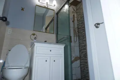 a bathroom with a toilet and a sink and a mirror at New York private room 29 in West New York