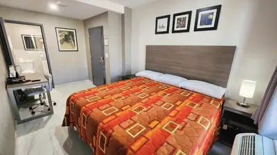 a bedroom with a bed and a desk in it at Hotel Fuego Bronx near Yankee Stadium in Bronx