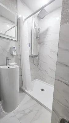 a white bathroom with a shower and a toilet at Hotel Fuego Bronx near Yankee Stadium in Bronx