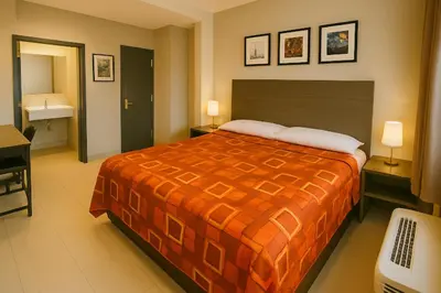 a hotel room with a bed and a bathroom at Hotel Fuego Bronx near Yankee Stadium in Bronx