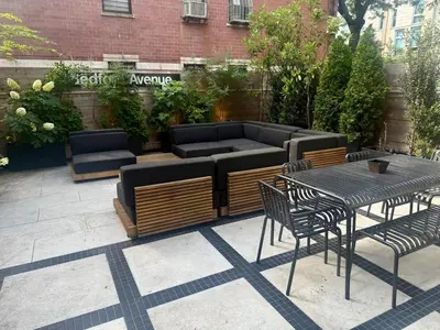 a patio with a couch and tables and chairs at Modern 2BR Brooklyn Retreat Near Manhattan with Private Backyard in Brooklyn