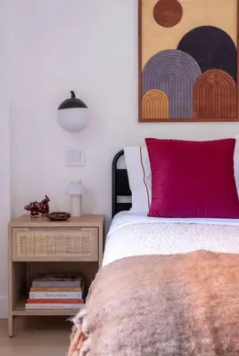 a bedroom with a bed with a red pillow and a table at Modern 2BR Brooklyn Retreat Near Manhattan with Private Backyard in Brooklyn