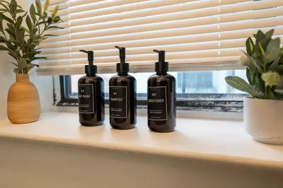 three bottles sitting on a window sill at Modern 3 Bedroom 7 minutes to Manhattan in Jersey City