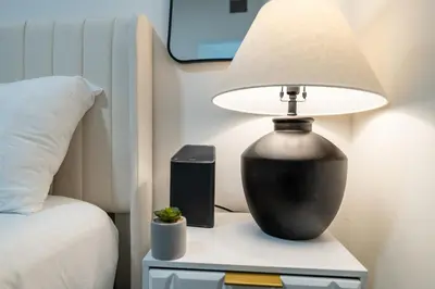 a lamp on a night stand next to a bed at Modern 3 Bedroom 7 minutes to Manhattan in Jersey City