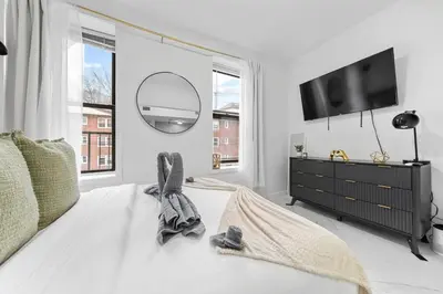 a bedroom with a bed with a mirror and a tv at Modern 3 Bedroom 7 minutes to Manhattan in Jersey City