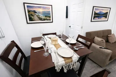 a dining room table with plates and glasses on it at JC Central Stylish Stay Near Manhattan 1A in Jersey City