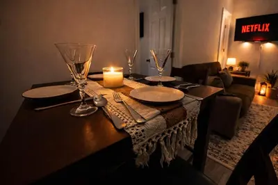 a table with a candle and plates and wine glasses at JC Central Stylish Stay Near Manhattan 1A in Jersey City