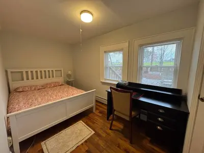 a bedroom with a bed and a desk and a piano at 3-bedroom peaceful apartment close to Fairfield University in Fairfield
