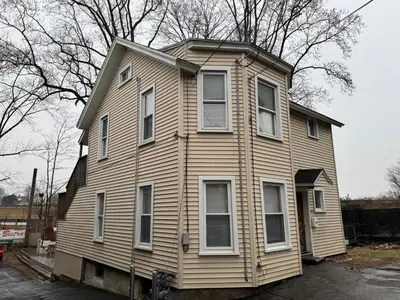 a wooden house with white windows on a street at 3-bedroom peaceful apartment close to Fairfield University in Fairfield