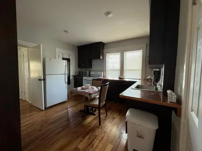 a kitchen with a white refrigerator and a table at 3-bedroom peaceful apartment close to Fairfield University in Fairfield