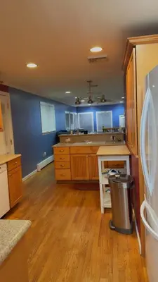 a large kitchen with blue walls and wooden floors at Stratford Getaway in Stratford