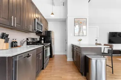a kitchen with stainless steel appliances and wooden cabinets at 2BR City Getaway - Close to NYC - Prime Location in Hoboken