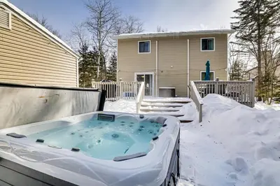 a hot tub in the snow in front of a house at Steps to Lake! Family Haven with Hot Tub in Poconos in Tobyhanna
