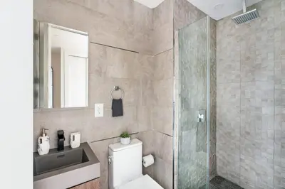 a bathroom with a toilet and a glass shower at 48-4FE 2BR Prime Midtown West in New York